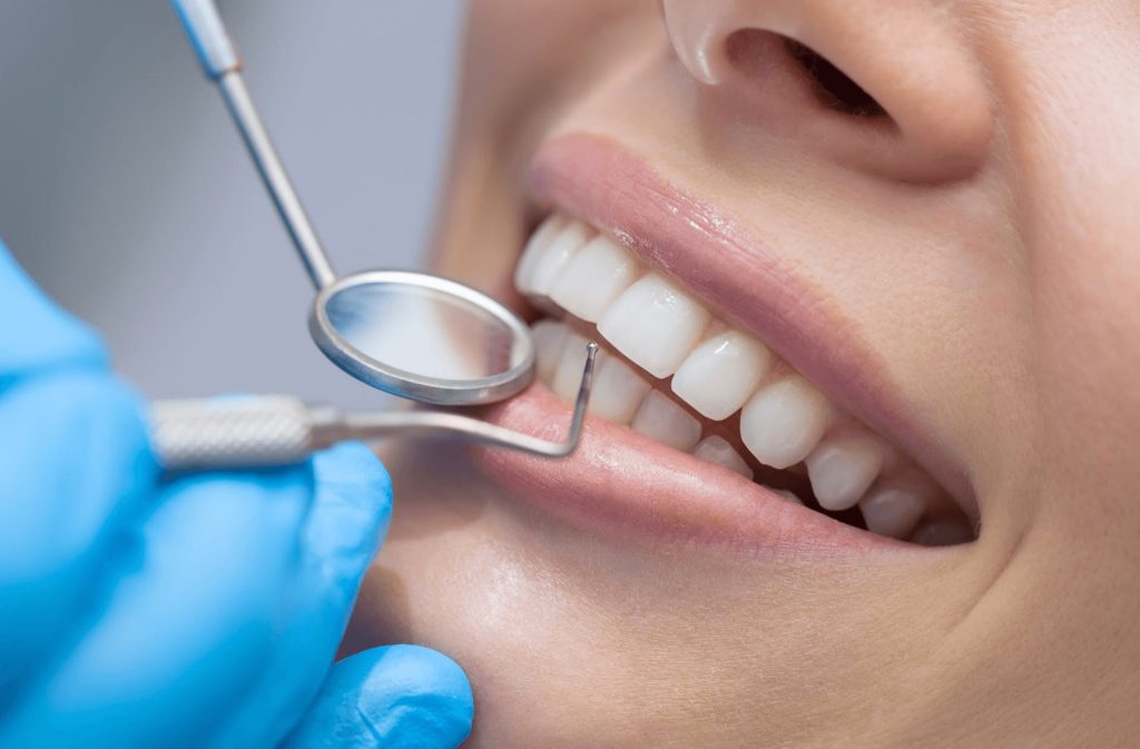 Dentist examining a patient's teeth with a mirror and probe
